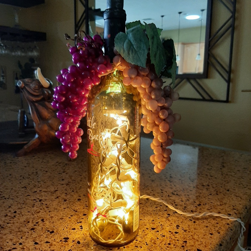 Wine bottle with lights and grapes.